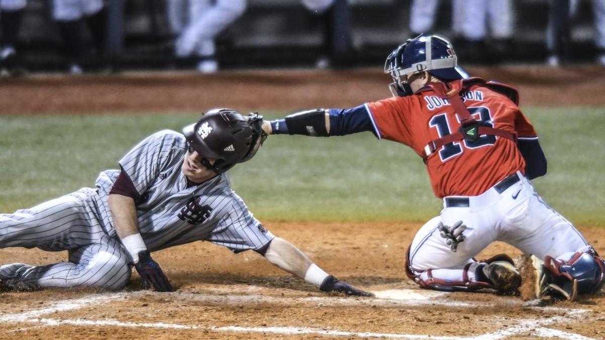 Mississippi State's Brent Rooker (19) scores against Ole Miss catcher Cooper Johnson (13) in Oxford, Thursday, March 30, 2017. Rooker helped lead MSU past Ole Miss on Tuesday in the annual Governor’s Cup game.