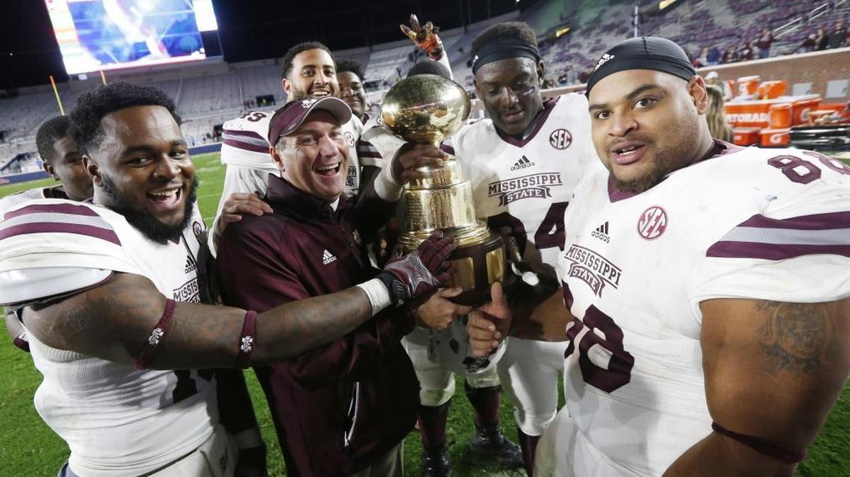 Mississippi State head coach Dan Mullen and his players pose for a photograph with the "Golden Trophy" as they celebrate their 55-20 win over Ole Miss in the annual Egg Bowl in Oxford, Nov. 26, 2016. The Bulldogs will host the Rebels at 6:30 p.m. Thursday.