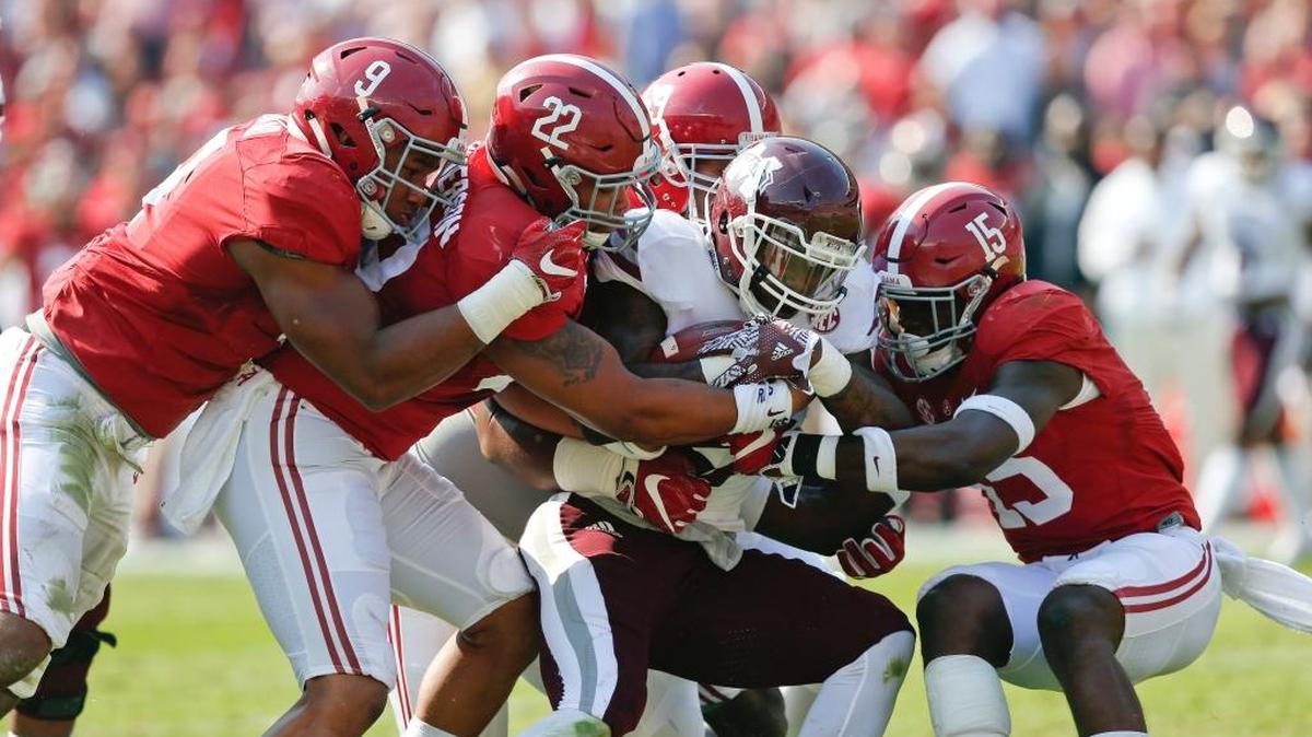 Mississippi State running back Aeris Williams, center, is tackled by Alabama defenders Saturday in Tuscaloosa, Ala.