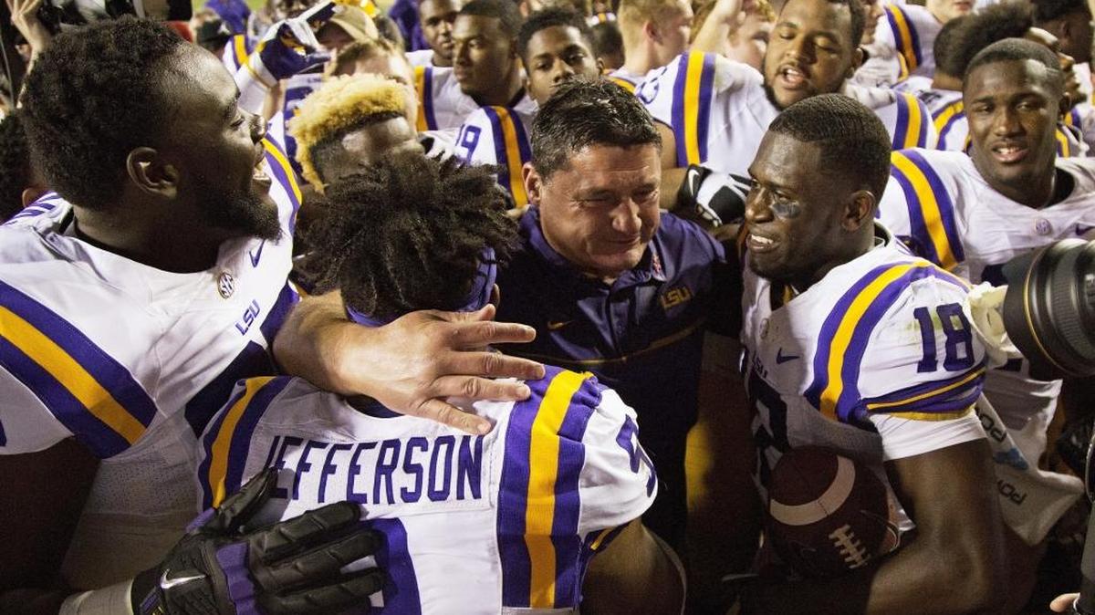LSU interim coach Ed Orgeron, center, celebrates with players, including offensive lineman Jakori Savage, left, safety Rickey Jefferson (9) and cornerback Tre'Davious White (18) after their game against Missouri in Baton Rouge, La., Saturday, Oct. 1, 2016. LSU won 42-7.