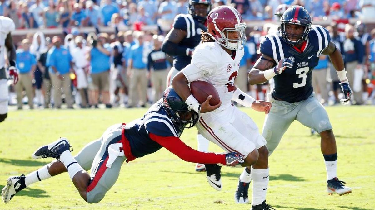 Alabama quarterback Jalen Hurts (2) runs through Ole Miss defenders Saturday in Oxford.