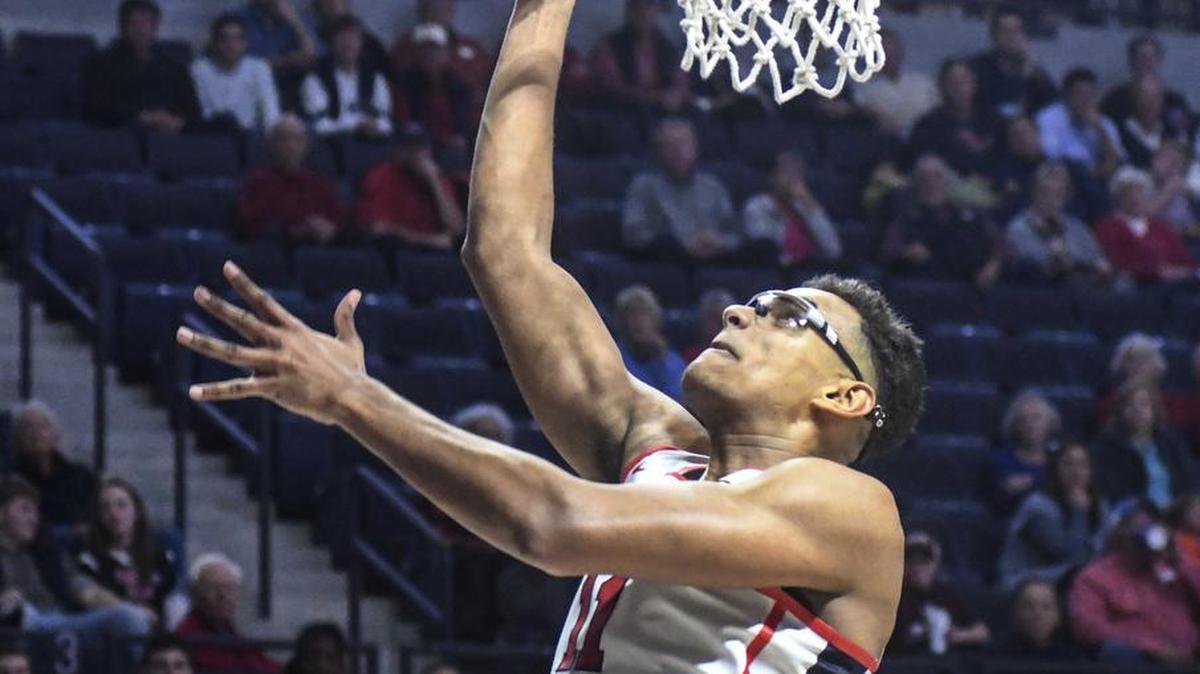 Ole Miss forward Sebastian Saiz (11) shoots between Texas A&M center Tonny Trocha-Morelos, left, and forward Robert Williams.