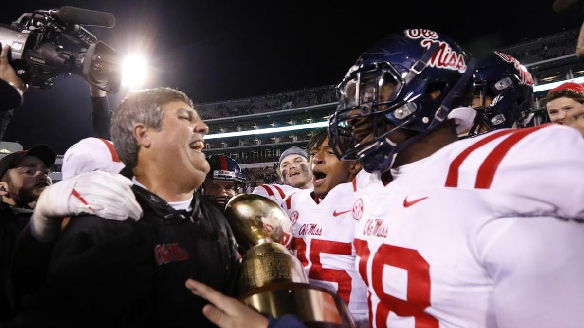 Ole Miss coach Matt Luke, left, celebrates with players following their 31-28 win over Mississippi State in the Egg Bowl NCAA college football game in Starkville, Miss., Thursday, Nov. 23, 2017. (AP Photo/Rogelio V. Solis)