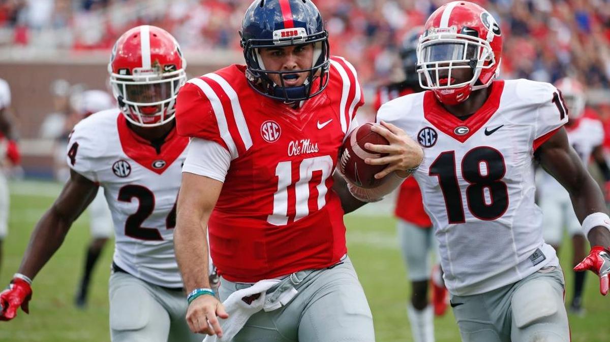 Ole Miss quarterback Chad Kelly (10) runs past Georgia cornerback Deandre Baker (18) and safety Dominick Sanders (24) for a 41-yard touchdown run Saturday. No. 23 Ole Miss won 45-14.
