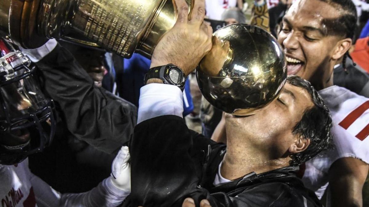 Ole Miss coach Matt Luke kisses the Golden Egg trophy following the team's 31-28 win over Mississippi State in Starkville, Thursday, Nov. 23, 2017.