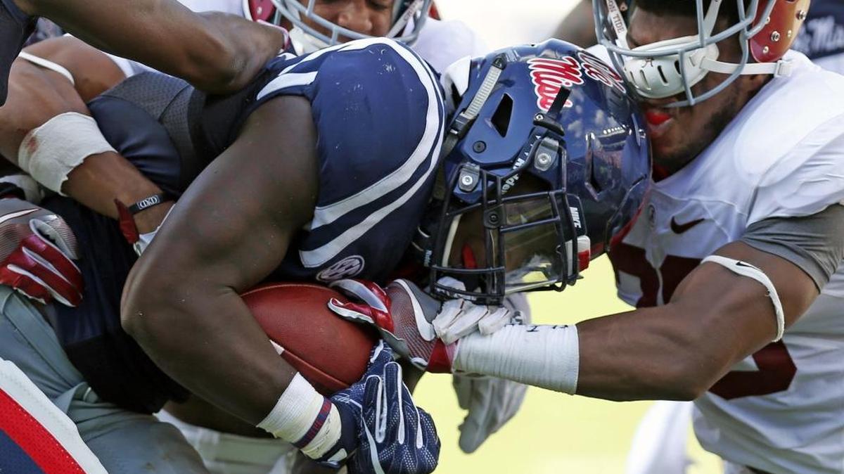 Ole Miss running back Akeem Judd, center, pushes against Alabama defensive back Marlon Humphrey, right, while rushing for extra yards Saturday in Oxford.