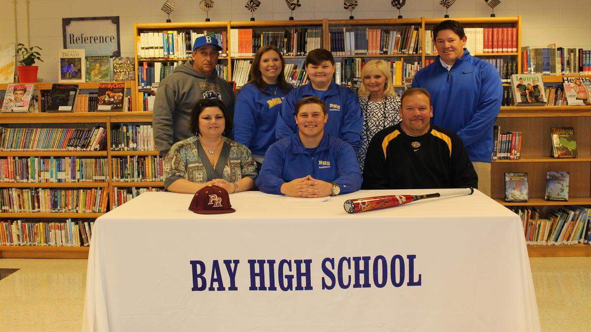 Tristian Hopgood signed a scholarship with Pearl River Community College. Seated in front from left: Colleen Hopgood, mother, Tristian Hopgood father Back row from left, Kevin Burdine Head coach, Amy Coyne, principal, Evan Hopgood, brother, June Curtin, grandmother, Will Seymour athletic director.