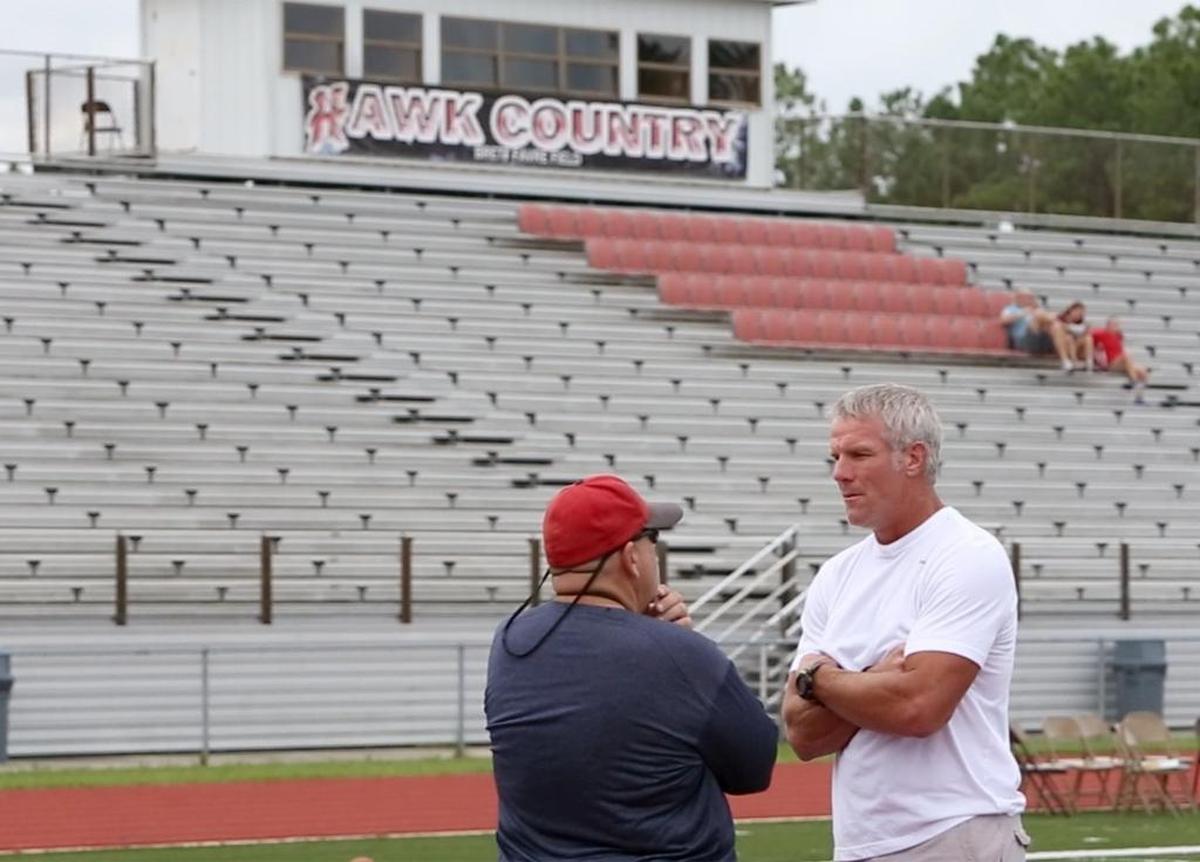 Pro Football Hall of Fame quarterback Brett Favre talks to Hancok High School head football coach Rocky Gaudin before a ceremony honoring Favre as a Hometown Hall of Famer at Hancock High School in Kiln on Tuesday, Aug. 16, 2016. Gaudin recently announced his retirement from HHS.