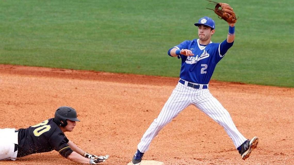 Ocean Springs shortstop Cooper Brune leaps for the ball as Oak Grove's Scott T. McMurrian dives back to second base, Saturday, March 26, 2016.