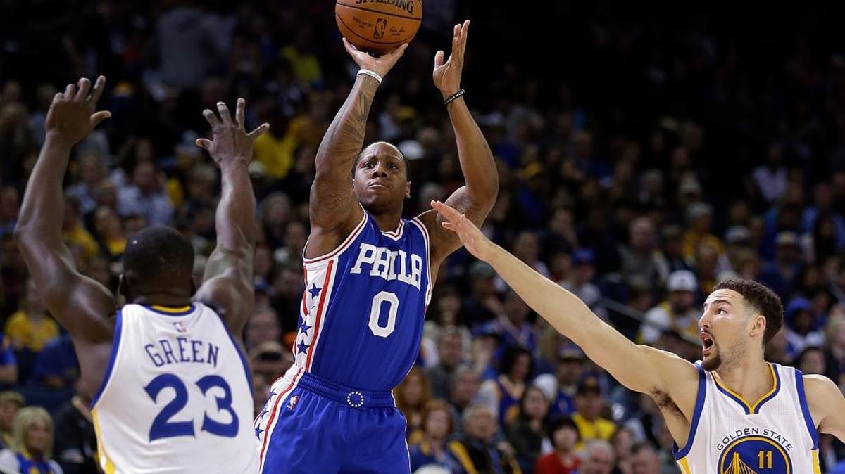 Philadelphia 76ers' Isaiah Canaan (0) shoots between Golden State Warriors' Draymond Green, left, and Klay Thompson, right, during the first half of an NBA basketball game Sunday, March 27, 2016, in Oakland, Calif.