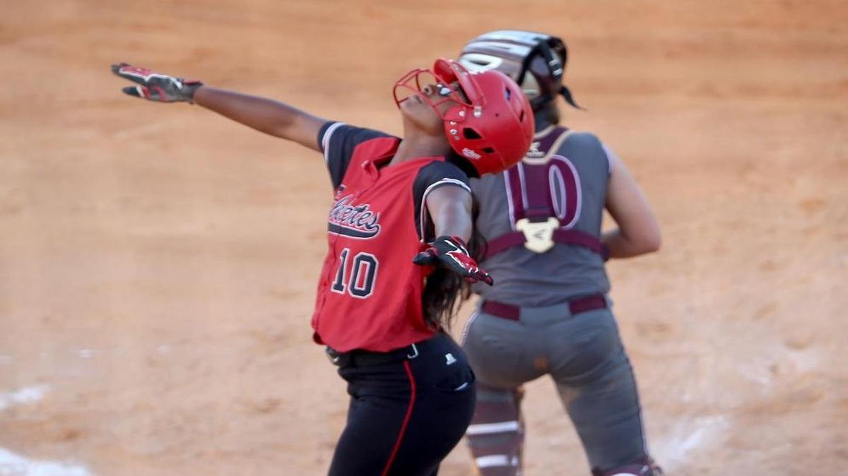 Harrison Central's Amari Ramsey signals she is safe after scoring a run against George County during second round of the MHSAA Class 6A softball playoffs at Harrison Central.