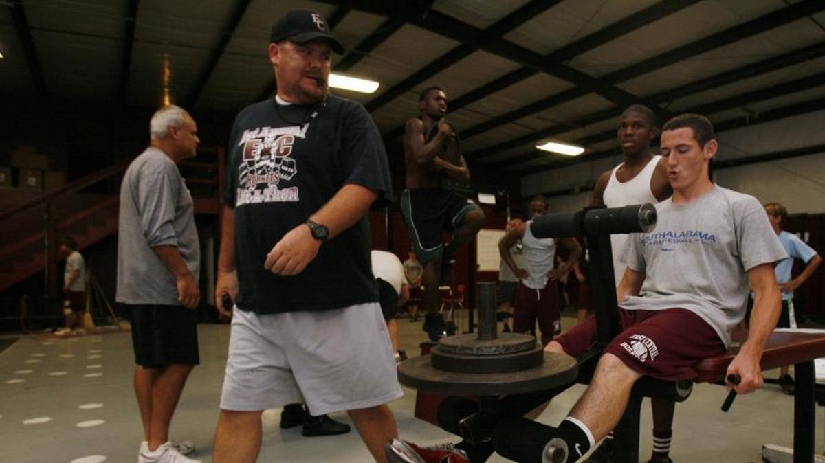 East Central High School head football coach Marc High pushes his players, including Bradley Green on leg extensions before the 2009 football season in Hurley.