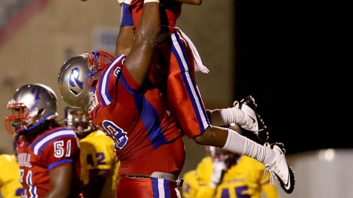 Pascagoula's James Jackson lifts teammate Cartreal Davison into the air after Davison scored a touchdown against Hattiesburg on Oct. 16, 2015, in Pascagoula.