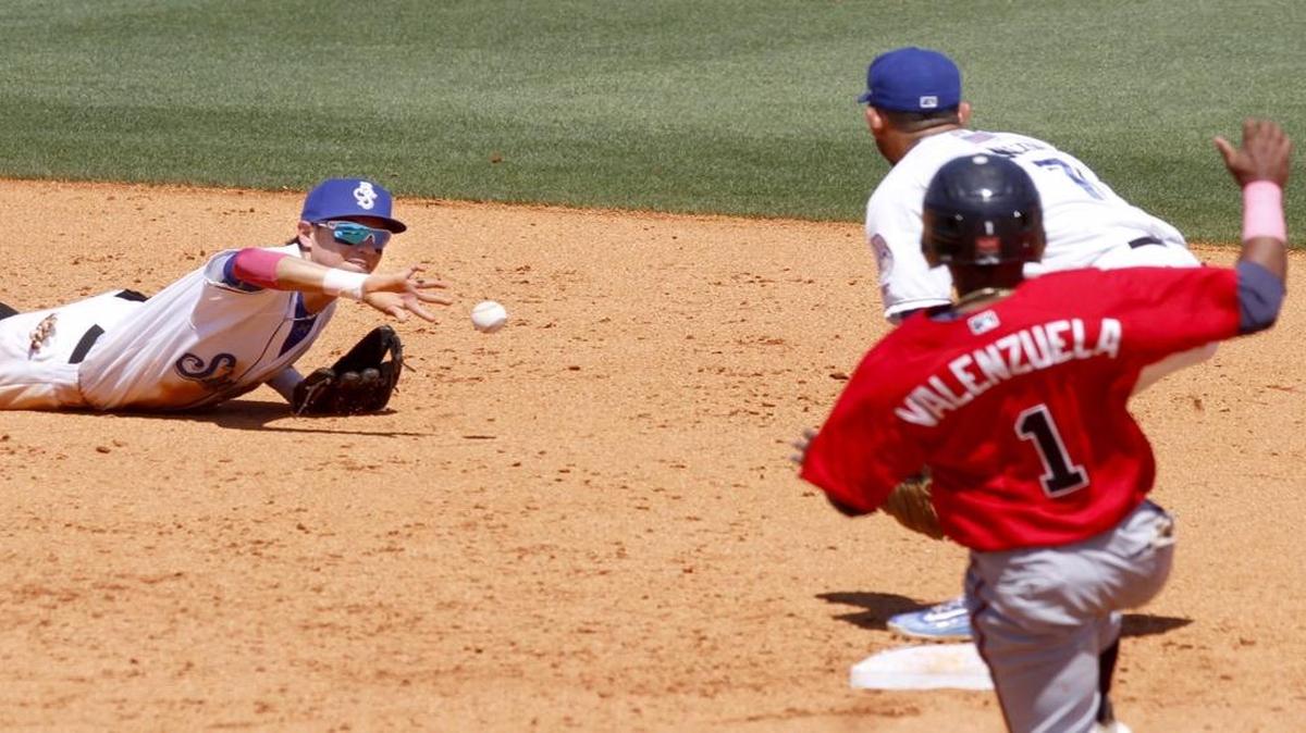 Shuckers shortstop Mauricio Dubon tries a back hand flip to Javier Betancourt after making a diving stop of a ground ball during game between the Shuckers and Braves. Braves runner Luis Valenzuela was safe on the play.