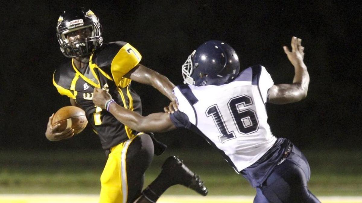 D’Iberville quarterback Jaden Walley tries to escape the rush of Moss Point’s Keandre Booker on Aug. 11, 2017, in D’Iberville.