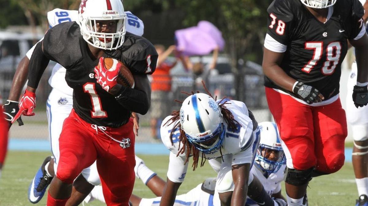 Harrison Central running back Keon Moore hits a hole against Jefferson Davis during the first quarter of their Port City Bowl Classic game at Milner Stadium on Gulfport on Friday, Aug. 18, 2017. St. Martin hosted Harrison Central on Friday.