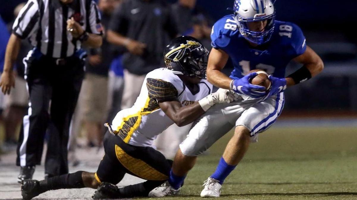 Ocean Springs' Austin Williams slips away from D'Iberville's D.J. Polk on Friday, September 30, 2016.