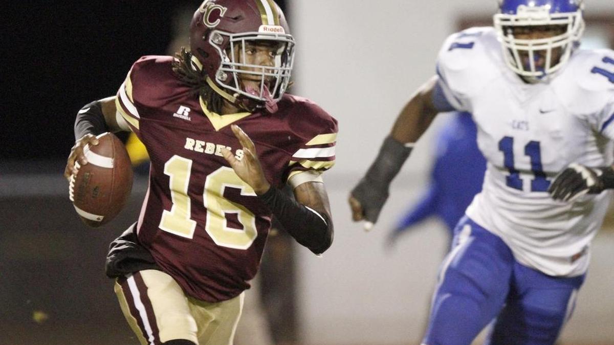 George County quarterback Laraymond Spivery rolls away from pressure from Meridian's Deuntra Hyman at 6A playoff game in Lucedale, Friday, Nov. 11, 2016.