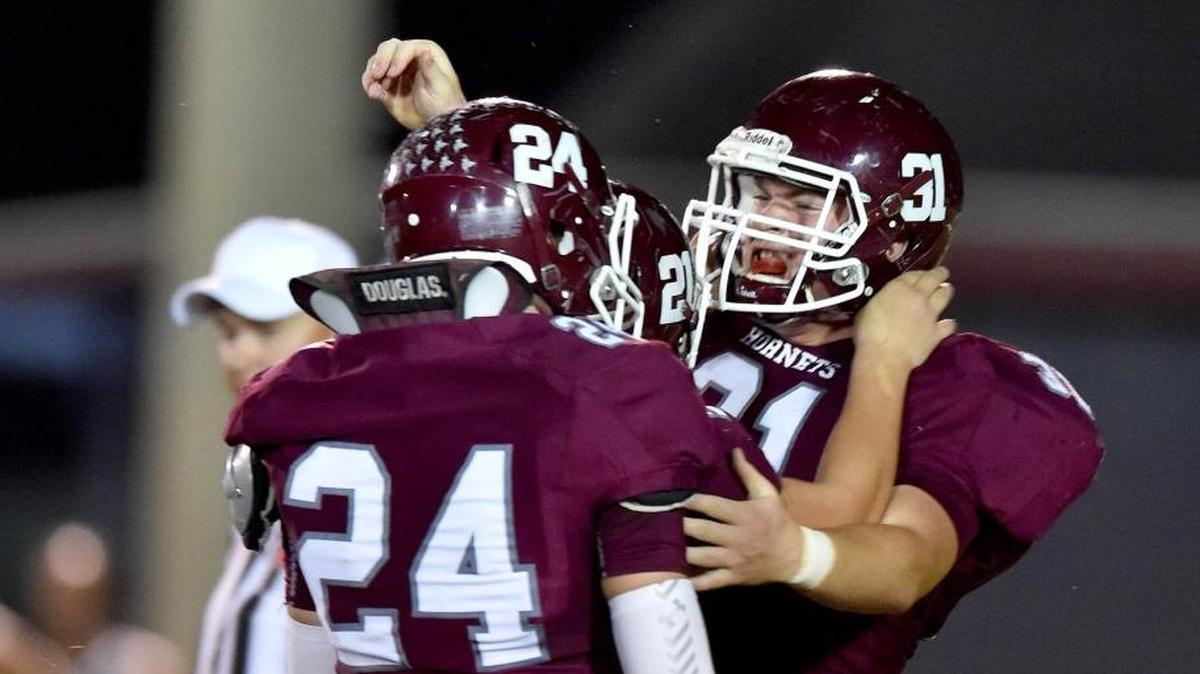 East Central defensive tackle Trace Higginbotham (31) celebrates with middle linebacker Avery White (24) and defensive end Joel Reiser (21) in Hurley on Sept. 29.