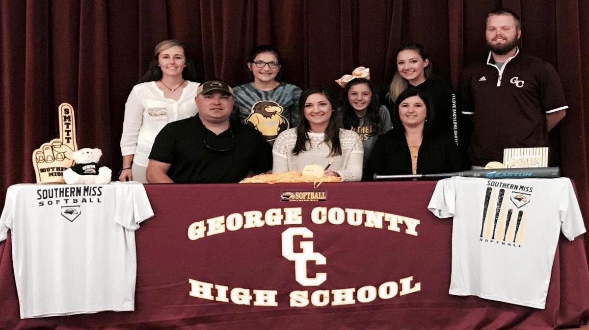 Joined by family and coaches, George County’s Kaitlyn Passeau (middle) signed a softball scholarship with Southern Miss on Wednesday.