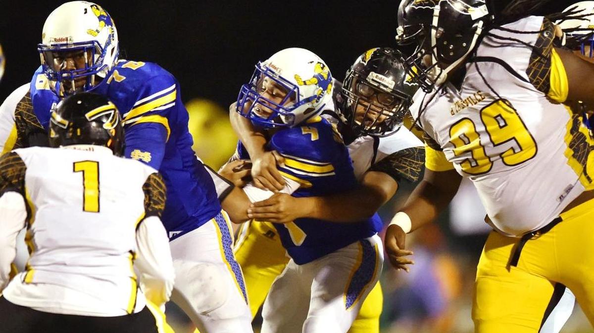 St. Martin quarterback Landon Pankonin (4) is tackled by D'Iberville defensive end Josh Quinn (42) Friday in St. Martin.