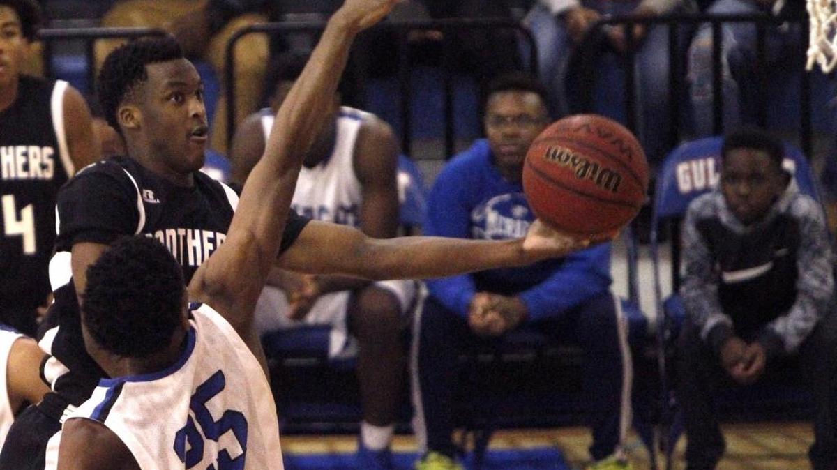 Pascagoula's Dequan Weatherspoon puts up a shot as Meridian's Ledarrius Brewer goes for the block during on Dec. 29 at Gulfport.