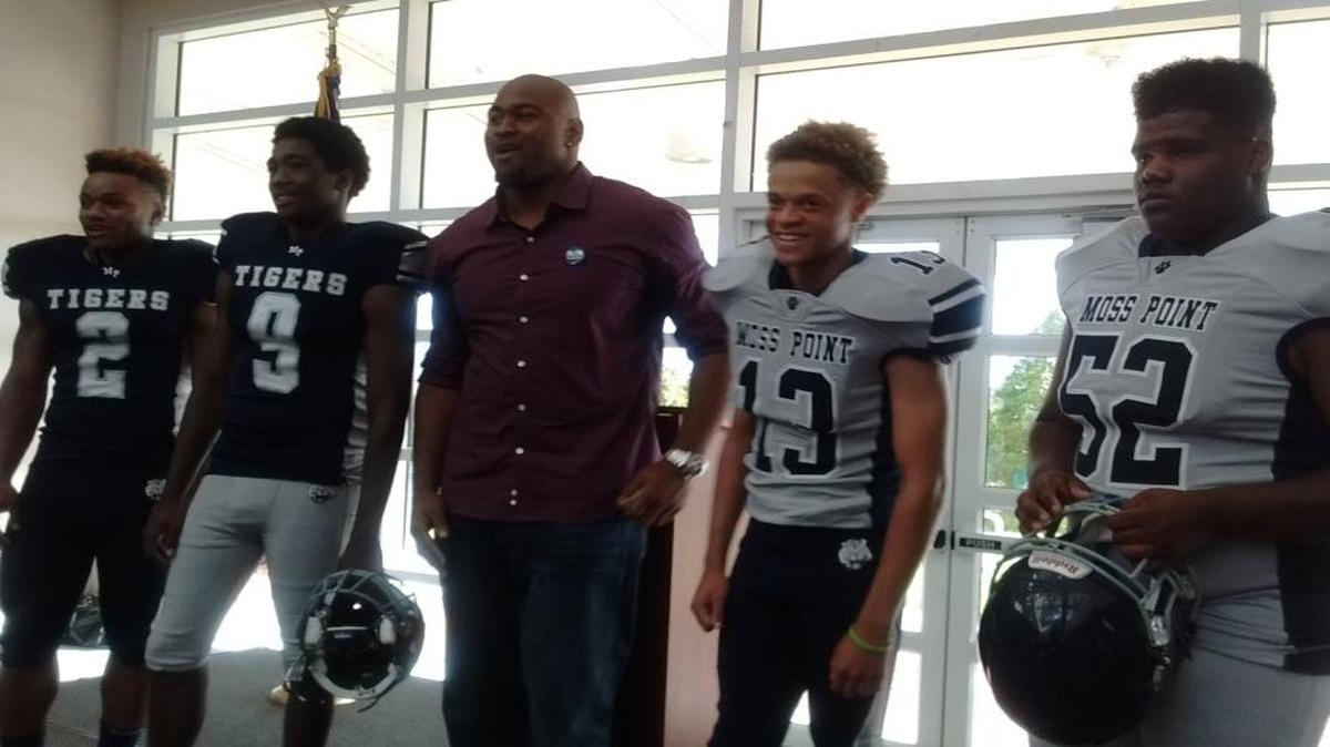 Minnesota Vikings defensive tackle Tom Johnson poses with current Moss Point Tigers (left to right) Omni Wells, Kobie Ruffin, Anthony Kirkland, and Anthony Sellers, who are modeling Moss Point's new uniforms. Johnson, a Moss Point graduate, bought the new uniforms.