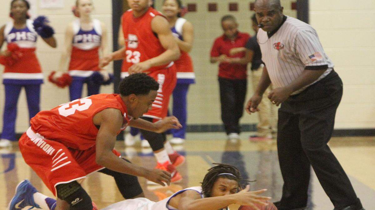 JOHN FITZHUGH/SUN HERALD
A referee watches as Pascagoula's Jakwaize Walker and Biloxi's Martell Turner dive for a loose ball during their game at Pascagoula High gym in December.