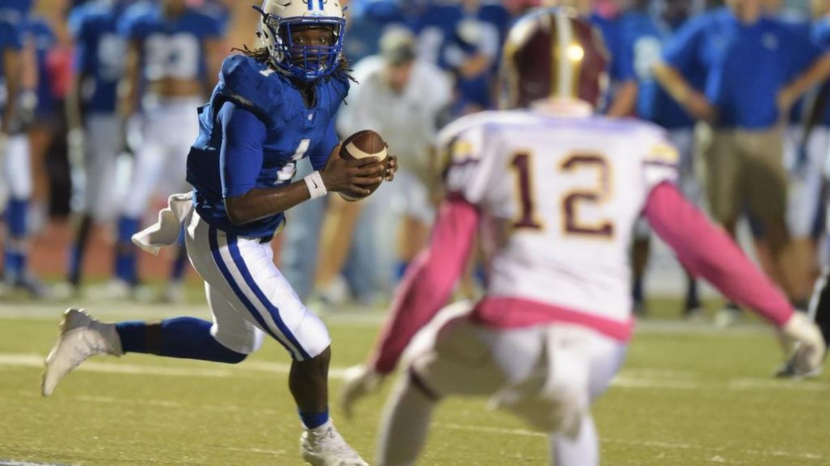 Ocean Springs quarterback Malcom Magee (1) rolls out as George County defensive back Joseph Lawrence (12) eyes him during the first quarter, Friday, Oct. 14, 2016, at Greyhound Stadium in Ocean Springs.