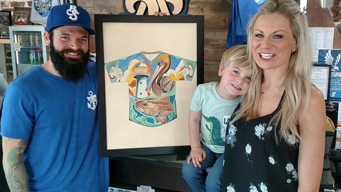 Ocean Springs tattoo artist Matt Stebly poses with the Biloxi Shuckers jersey he designed along with his son, Anderson, and wife, Jenna, at Twisted Anchor Tattoo in Ocean Springs. The jersey will be worn by the Shuckers during an April 22 home game at MGM Park.