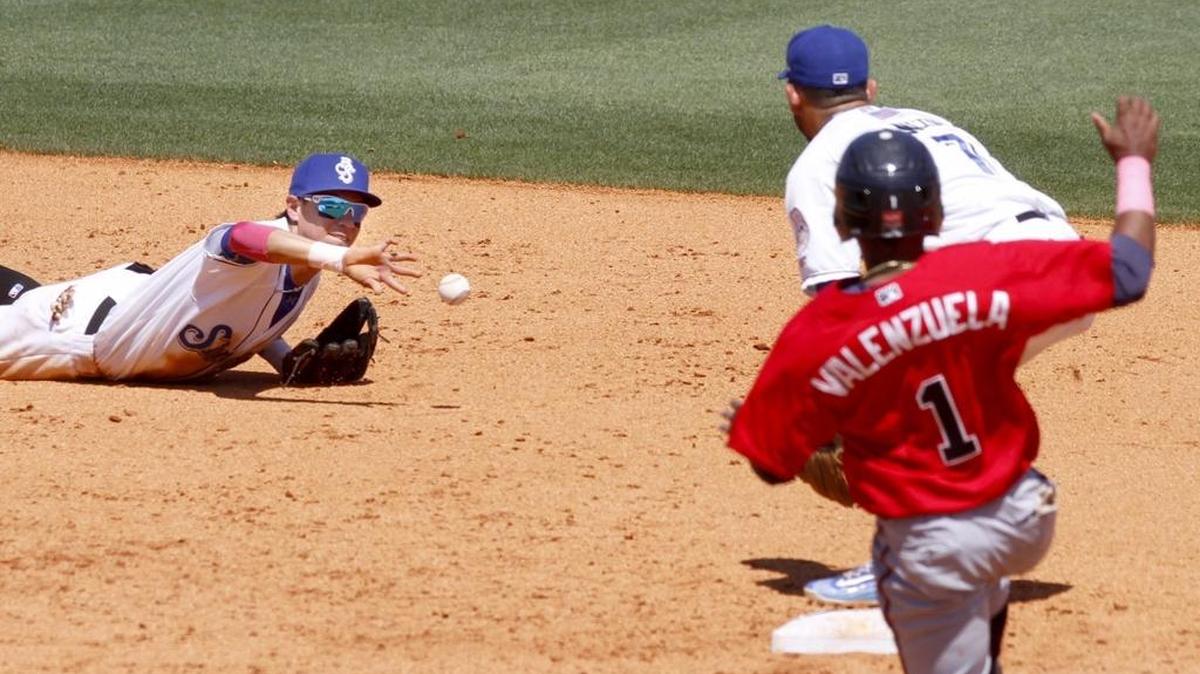 Shuckers shortstop Mauricio Dubon tries a back hand flip to Javier Betancourt after making a diving stop of a ground ball during game between the Shuckers and Braves. Braves runner Luis Valenzuela was safe on the play. Dubon was named a Southern League all-star Wednesday.