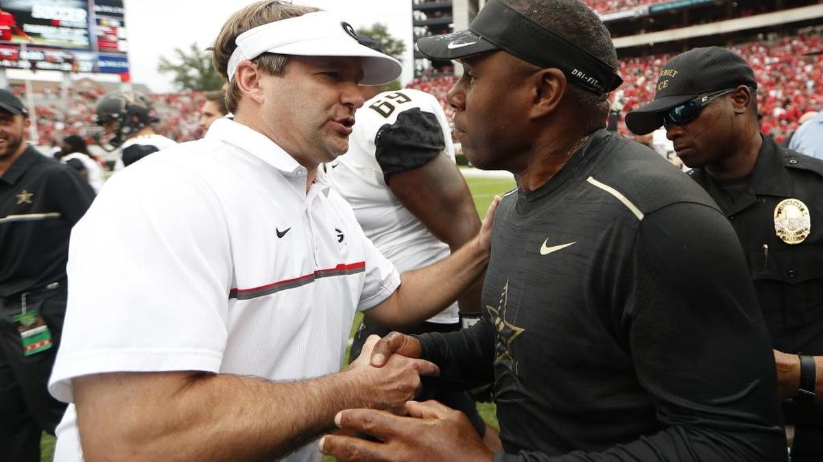 Georgia head coach Kirby Smart, left, and Vanderbilt head coach Derek Mason meet at midfield after Saturday’s game in Athens, Ga. Vanderbilt won 17-16.