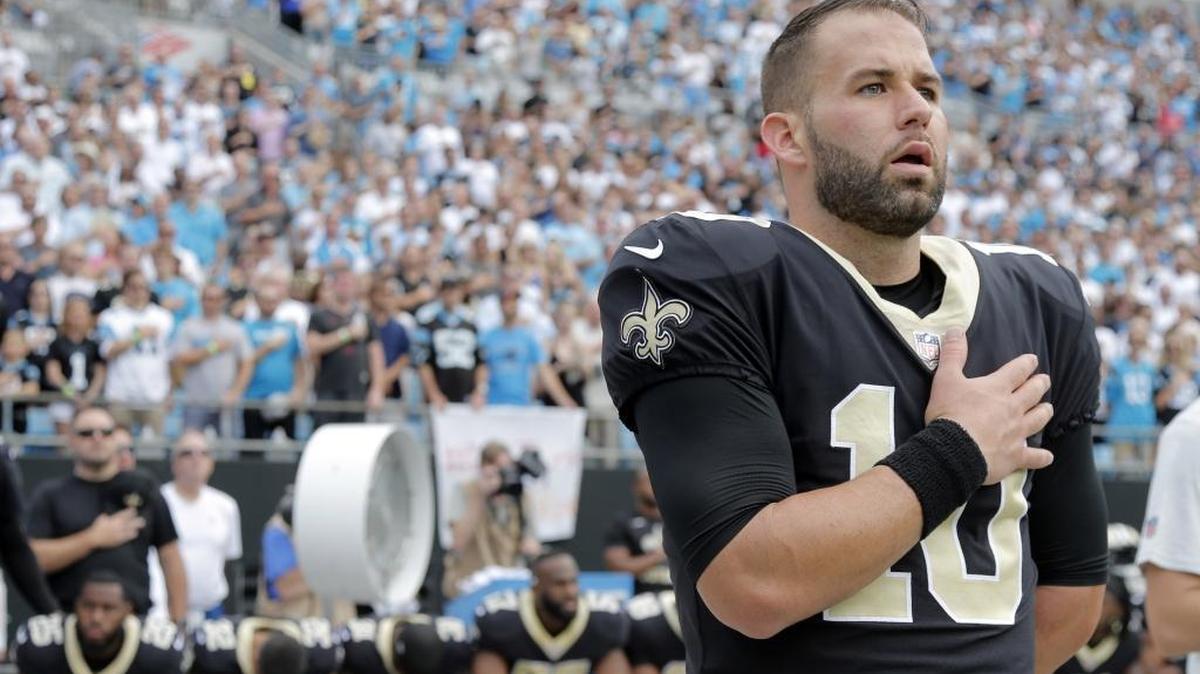 FILE - In this Sunday, Sept. 24, 2017, file photo, New Orleans Saints quarterback Chase Daniel (10) stands with his hand over his heart during the national anthem as other Saints players sit on the bench before an NFL football game against the Carolina Panthers in Charlotte, N.C.