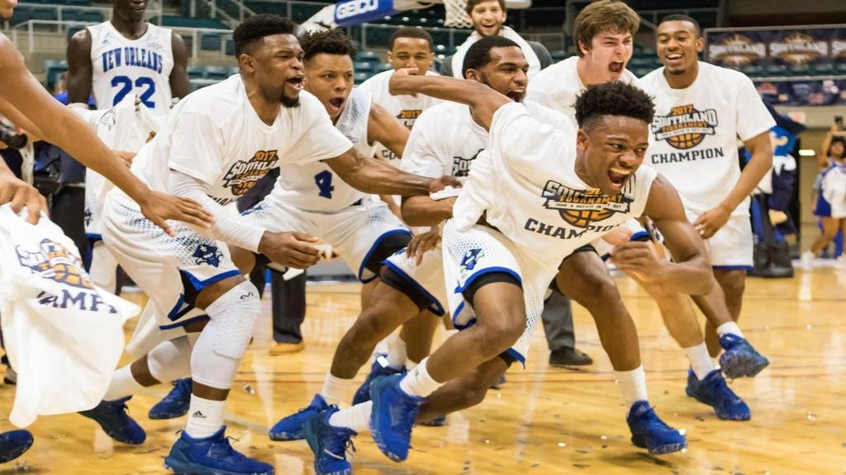New Orleans' Matthew Jiles, front, runs to grab the championship trophy after the team defeated Texas A&M-Corpus Christi 68-65 in overtime for the championship of the Southland Conference tournament. New Orleans advanced to a First Four contest on Tuesday.