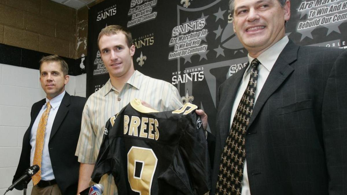 New Orleans Saints and former San Diego quarterback Drew Brees, center, holds a Saints jersey presented to him by General Manager Mickey Loomis, right, as Saints coach Sean Payton looks on at news conference at the New Orleans Saints training facility in Metairie, La. Wednesday March 15, 2006. Brees a free agent from the San Diego Chargers football team signed a new contract with the New Orleans Saints.