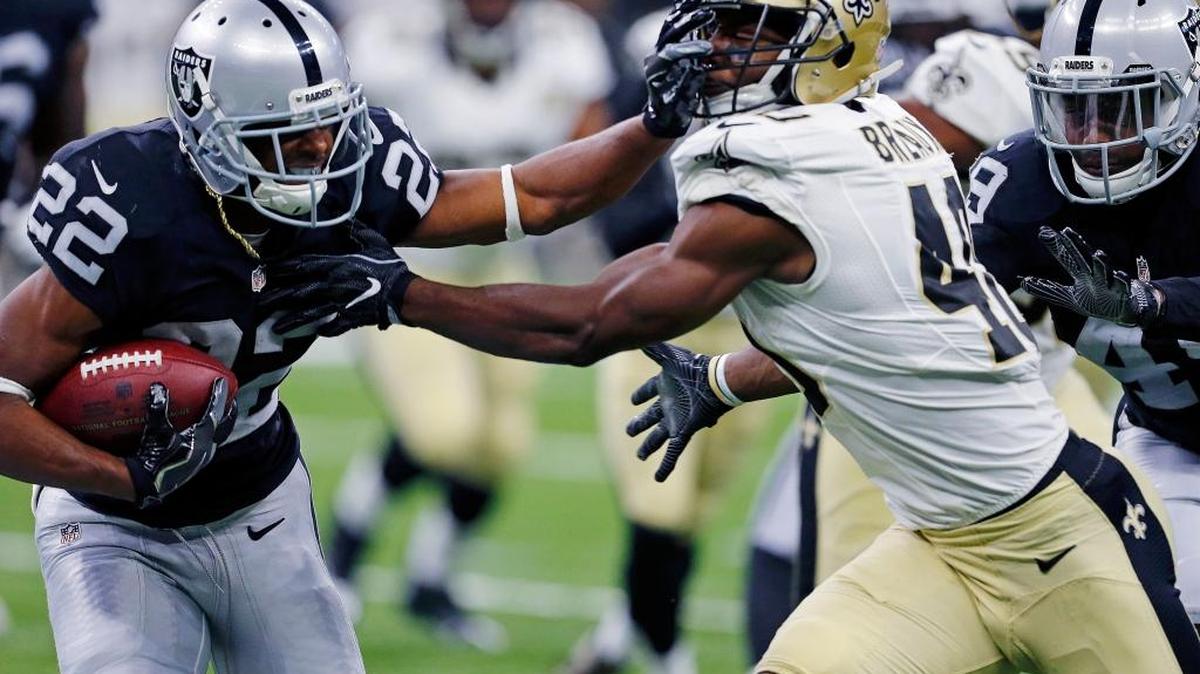Oakland Raiders running back Taiwan Jones (22) carries against New Orleans Saints cornerback Delvin Breaux (40) in the first half of an NFL football game in New Orleans, Sunday, Sept. 11, 2016. Breaux broke his fibula against the Raiders and is expected to be out six weeks.