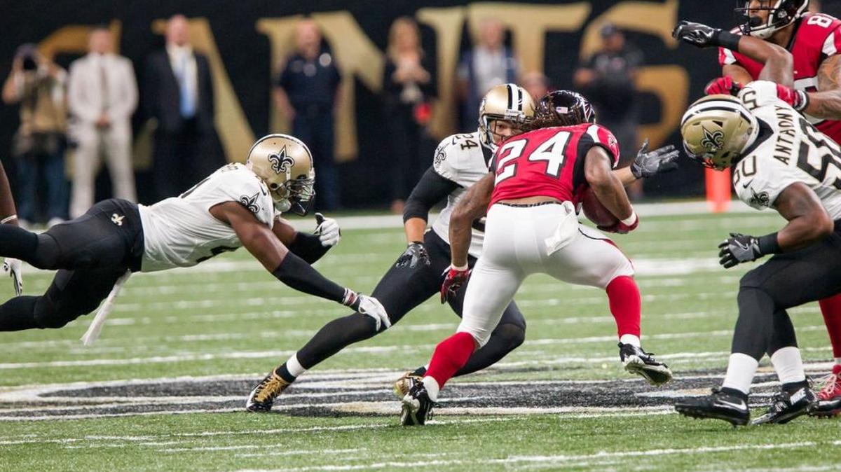 Atlanta Falcons running back Devonta Freeman (24) gets past New Orleans defensive back Roman Harper (41), Saints defensive back Sterling Moore (24) and outside linebacker Stephone Anthony (50) on Sept. 26 at the Mercedes-Benz Superdome.