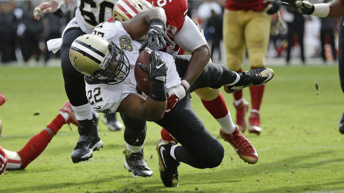 New Orleans Saints running back Mark Ingram carries the ball toward the goal line for a touchdown as San Francisco 49ers defensive end Ronald Blair (98) hangs on.