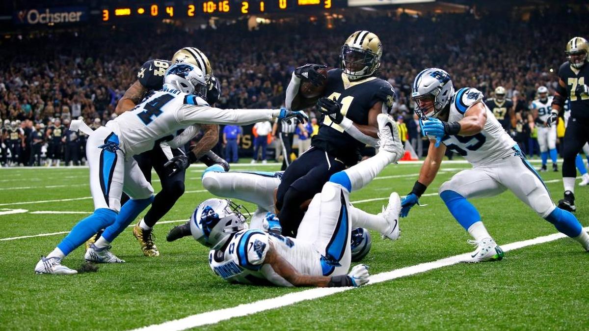New Orleans Saints running back Alvin Kamara (41) carries for a touchdown as Carolina Panthers middle linebacker Luke Kuechly (59), cornerback James Bradberry, left, and linebacker Shaq Thompson (54) try to stop him.