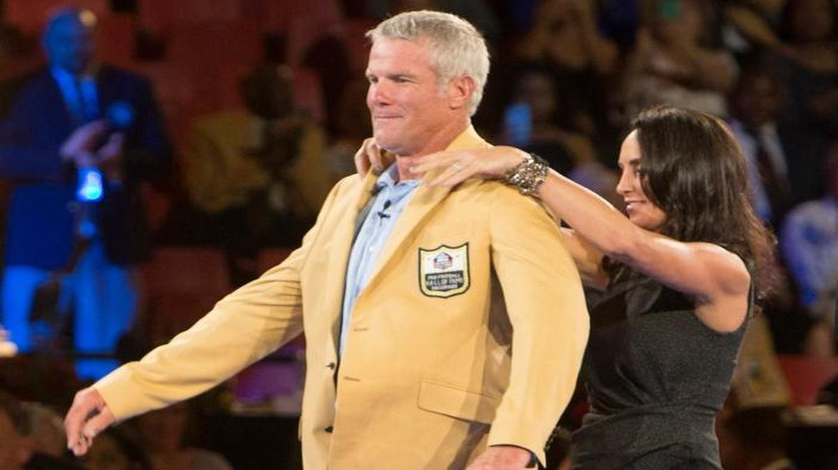Brett Favre receives his gold jacket from his wife, Deanna, at the Pro Football Hall of Fame enshrinees' dinner, Thursday in Canton, Ohio.