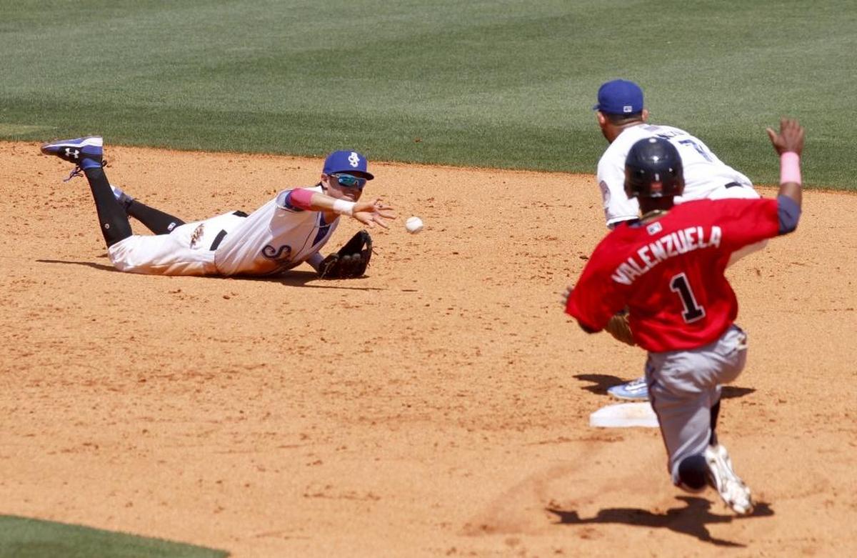 Shuckers shortstop Mauricio Dubon tries a back hand flip to Javier Betancourt after making a diving stop of a ground ball during a game between the Shuckers and Braves. Braves runner Luis Valenzuela was safe on the play. Photographer’s comment: The shortstop made a diving catch. I stuck with the play to see how he would try to get the out. I was rewarded with this backhand flip to second base.