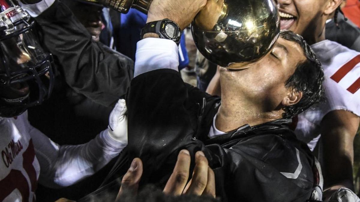 Ole Miss interim coach Matt Luke kisses the Golden Egg trophy following the team's 31-28 win over Mississippi State during an NCAA college football game in Starkville, Thursday, Nov. 23, 2017. Luke was named Ole Miss’ head coach after leading the Rebels to a 6-6 season.