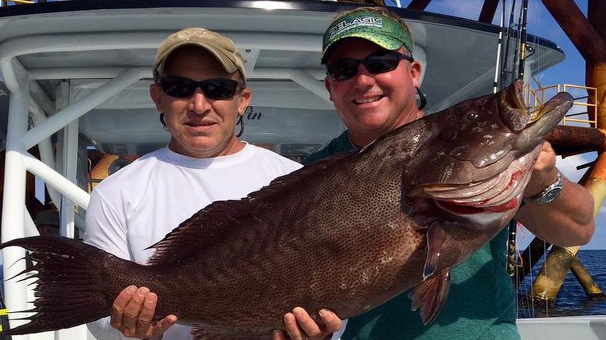 Joey Antoon, left, and Brandon Bosarge pose with a Scamp that Antoon caught in June. The fish set a new state record for Scamp, and the MCMR certified the record on Tuesday.