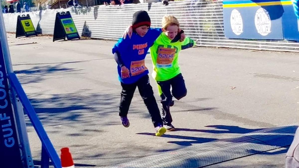 Nine year olds Ethan Bordelon and Logan Spain, cross the finish line together in the Chevron Kids Marathon.