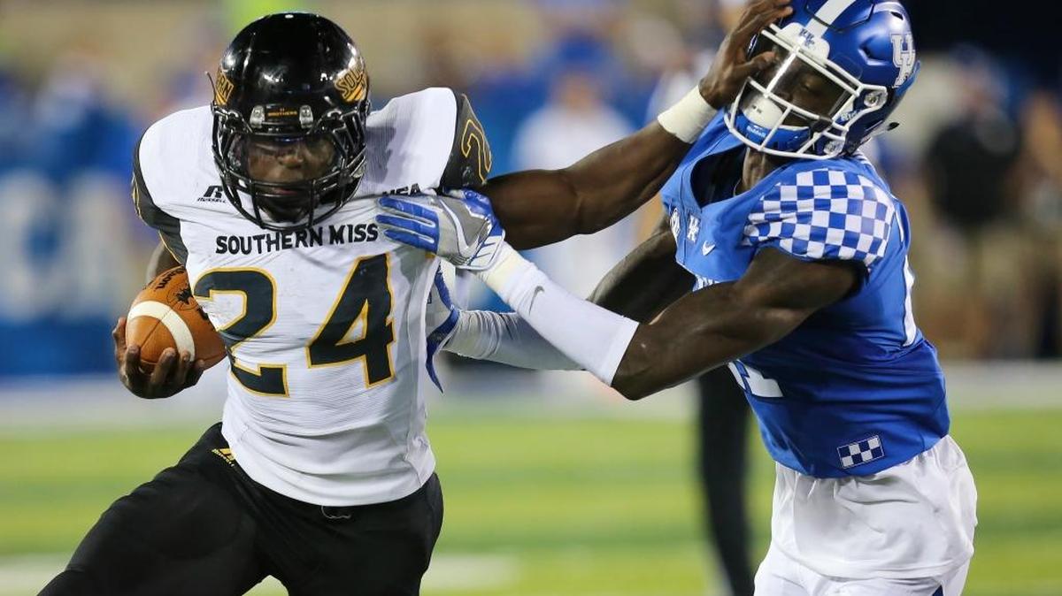 Southern Miss running back George Payne tries to keep out of the grip of Kentucky cornerback Chris Westry Saturday in Lexington, Ky. Southern Miss won the game 44-35.