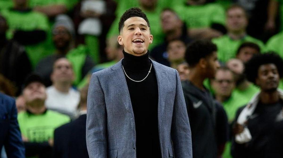 Injured Phoenix Suns guard Devin Booker steps out onto the court following a foul call against the Minnesota Timberwolves on Dec. 16 in Minneapolis.