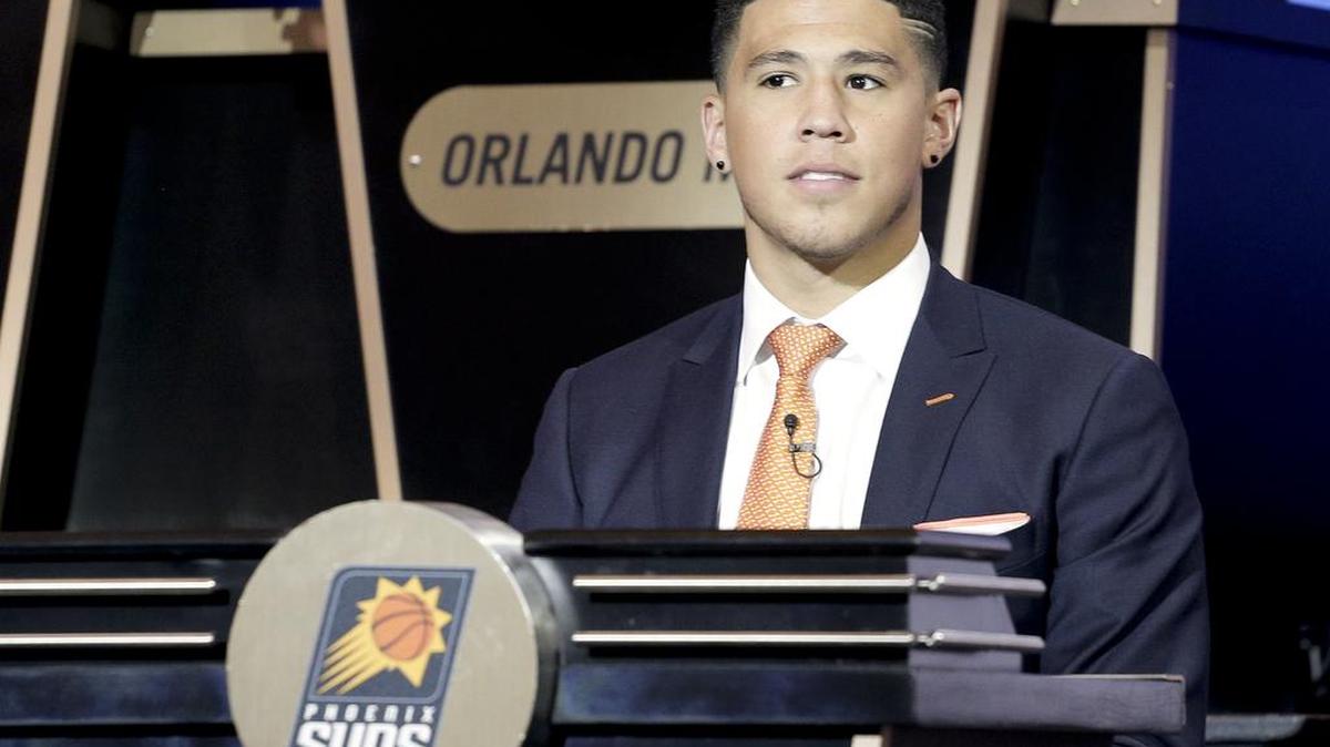 Phoenix Suns guard Devin Booker listens as the results of the NBA basketball draft lottery are announced on May 17 in New York.
