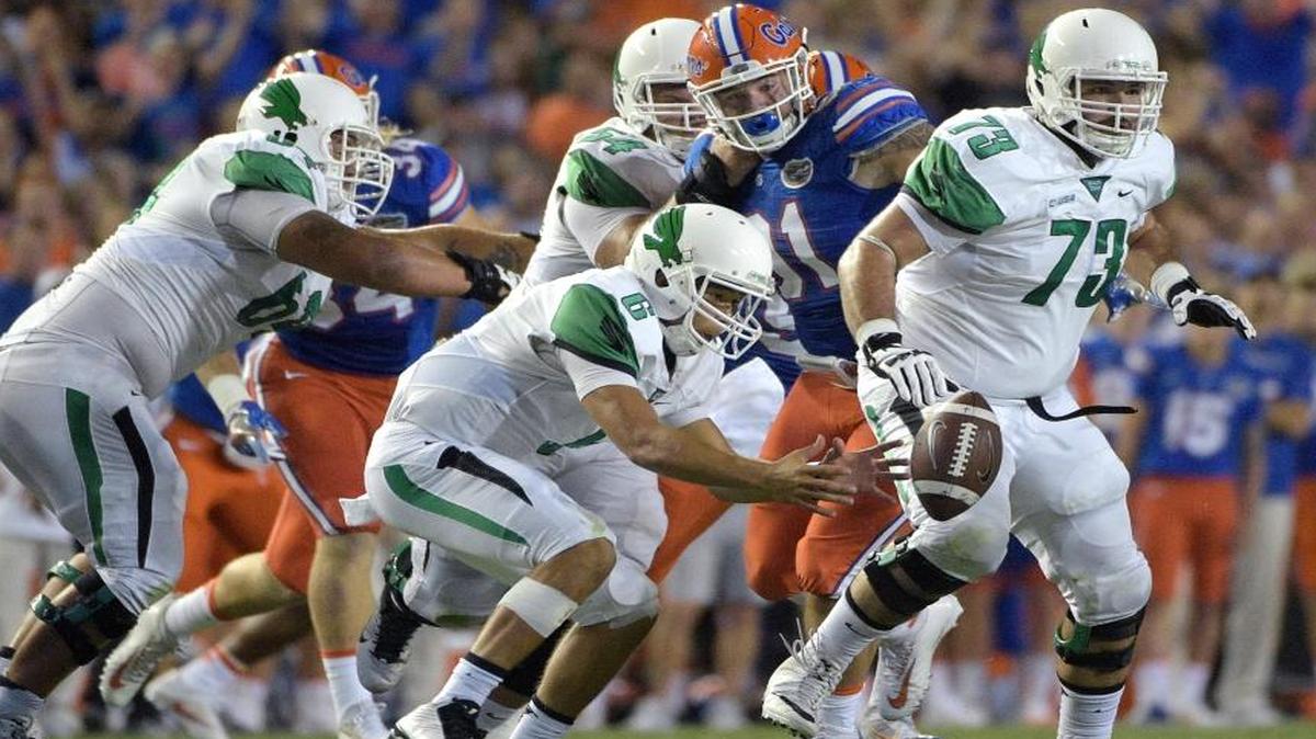 North Texas quarterback Mason Fine (6) recovers his own fumble in front of Florida defensive lineman Joey Ivie (91) after mishandling the snap during the first half of an NCAA college football game in Gainesville, Fla., Saturday.