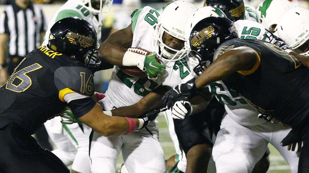 North Texas running back Jeffrey Wilson (26) is tackled by Southern Mississippi linebacker Elijah Parker (16) and defensive lineman Michael Smith (91) on Oct. 3, 2015, in Hattiesburg.