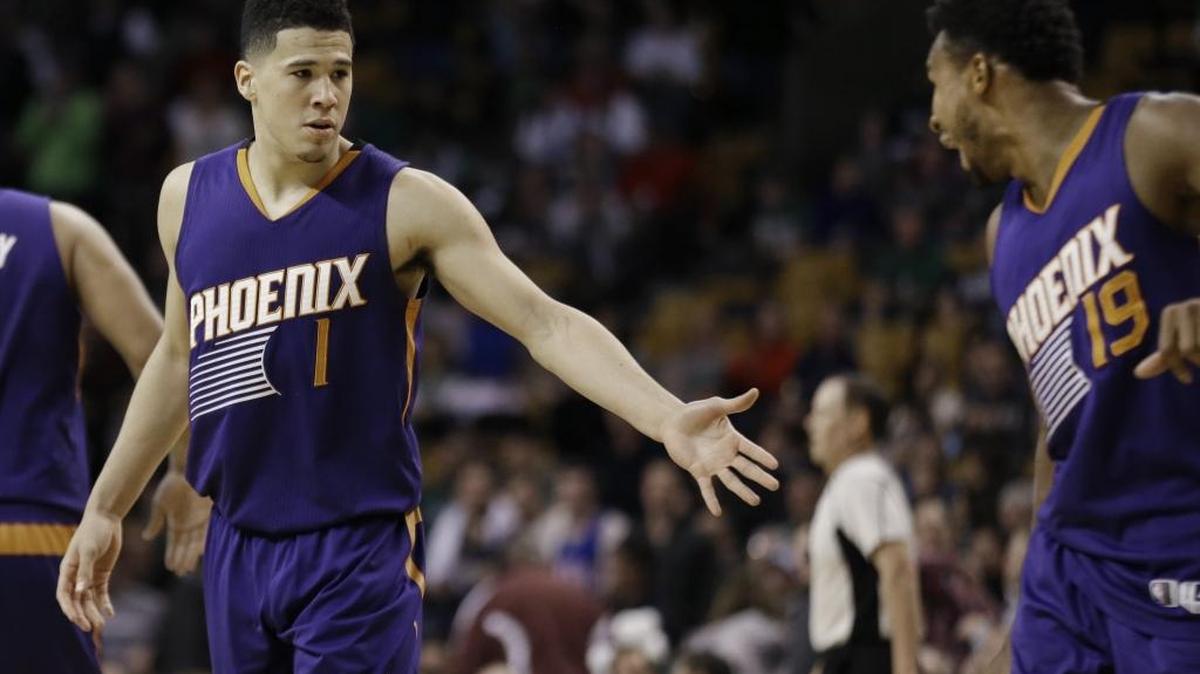 Phoenix Suns guard Devin Booker (1) is congratulated by guard Leandro Barbosa (19) in the fourth quarter of a game against the Boston Celtics Friday in Boston. Booker scored 70 points, but the Celtics won 130-120.